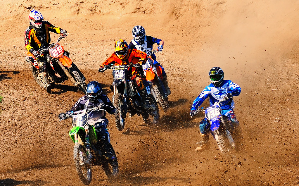 Grupo de motos de motocross atacando una curva de tierra