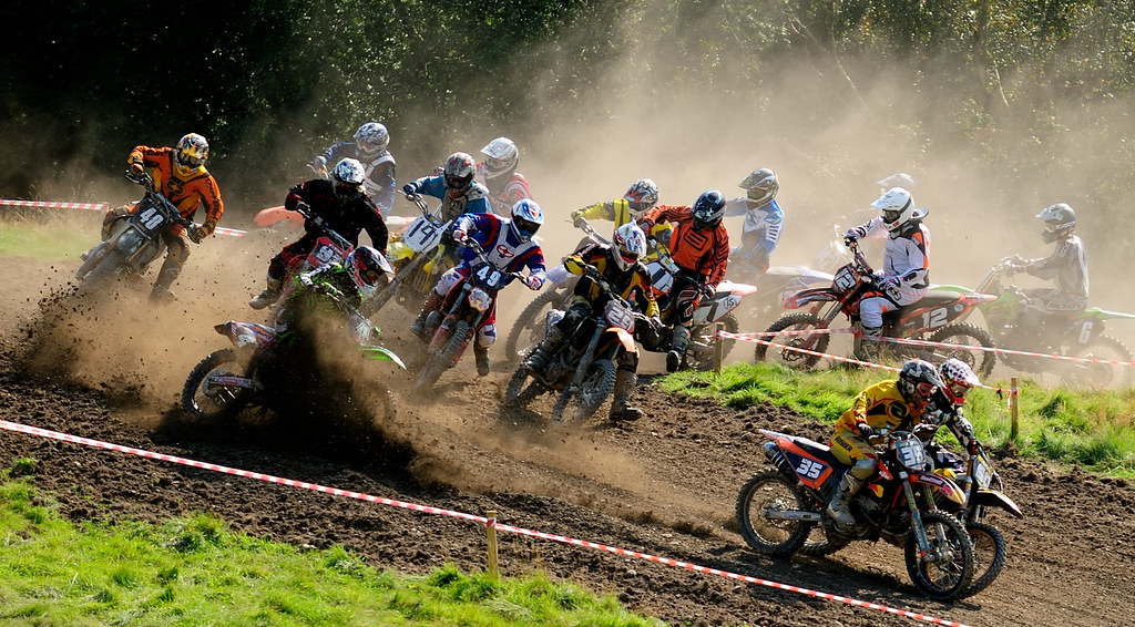 Salida de motocross con polvo a contraluz