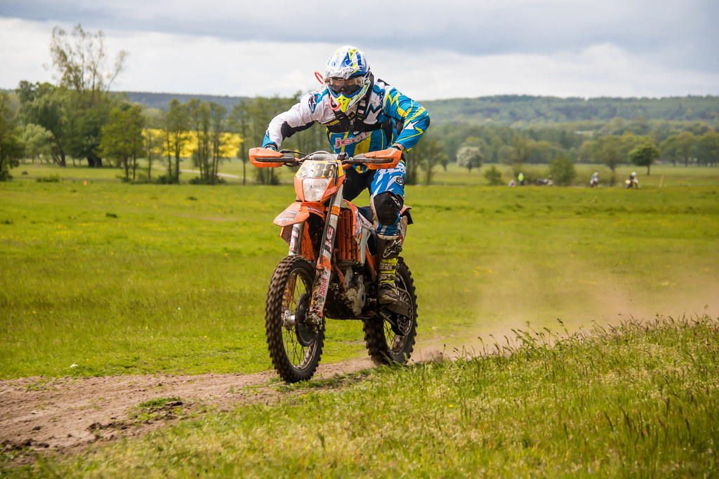 Moto de enduro KTM cruzando una pradera